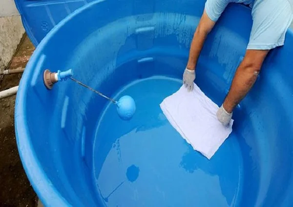 Imagem de pessoa passando pano limpo no fundo da caixa d'água