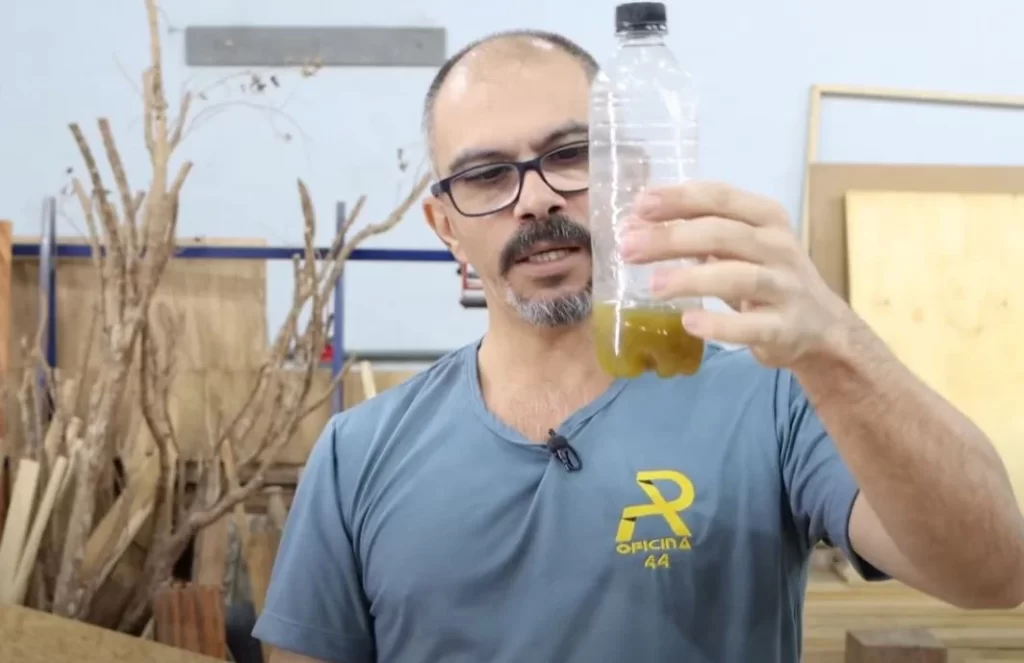 Foto do Adilson Pinheiro segurando uma garrafa com chá verde.